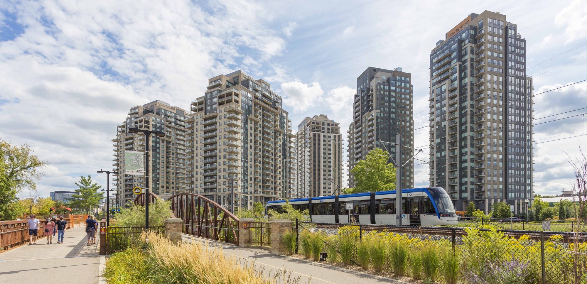 The ION Light Rail Transit train passes by the Barrel Yards residential complex in Uptown Waterloo.