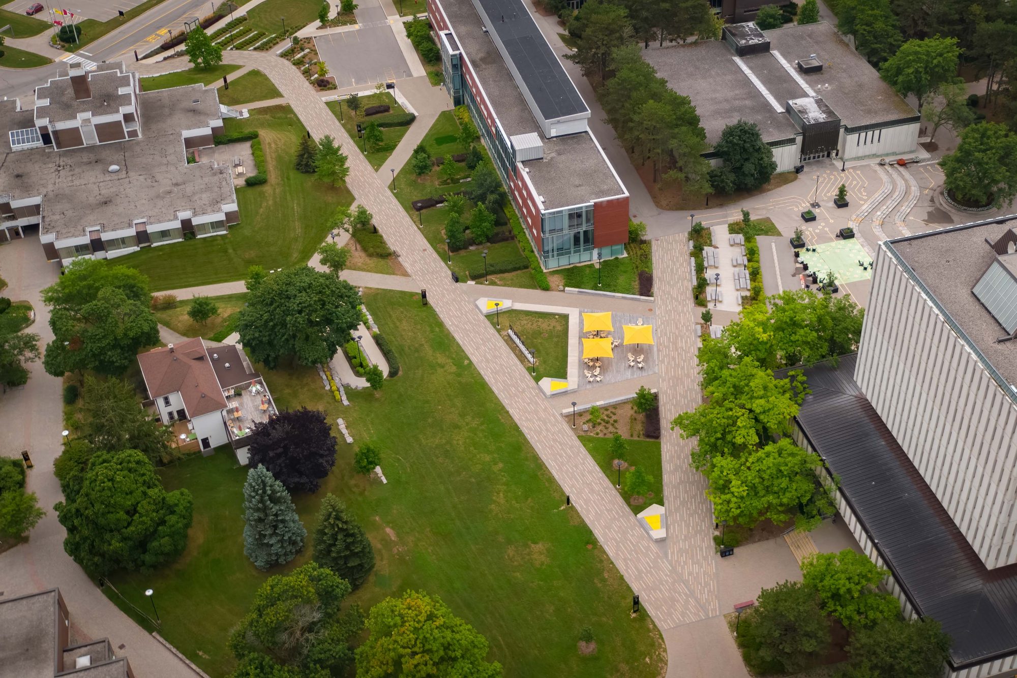 Wide angle aerial view of the University of Waterloo campus grounds showing path towards the South Common area via linear interlocked paving.