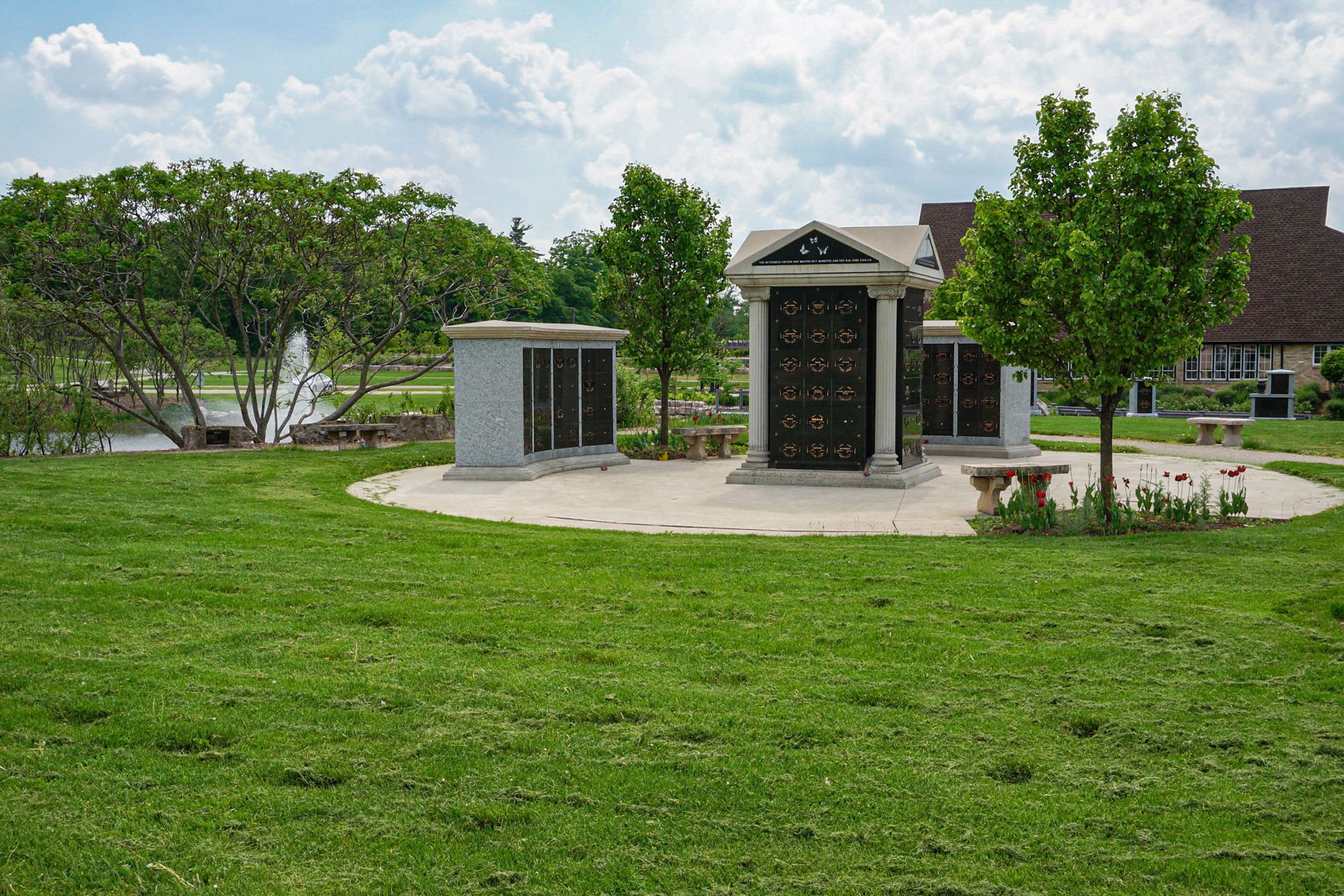 A series of columbaria structures with concrete seating in front of a church
