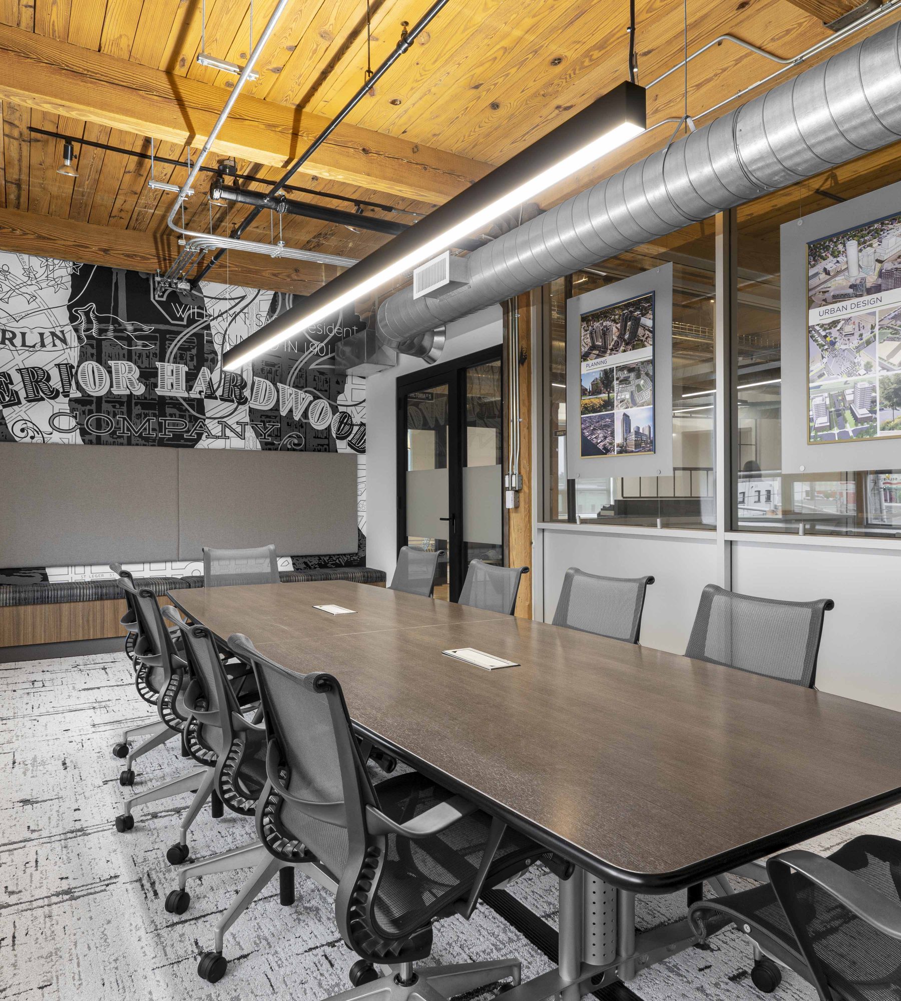 Interior view of boardroom with a black and white mural on the back wall and a boardroom table with ten chairs.