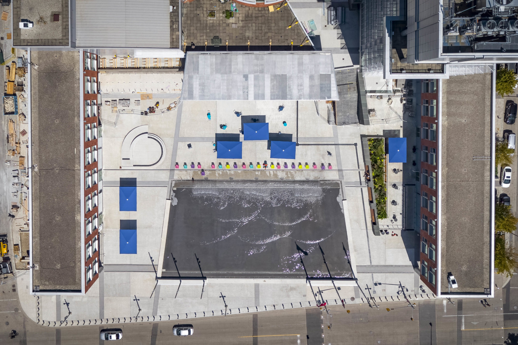 Aerial view of Kitchener City Hall Outdoor spaces with a water feature in the centre that will be a skating rink in the winter months. The rink is surrounded by City Hall buildings.